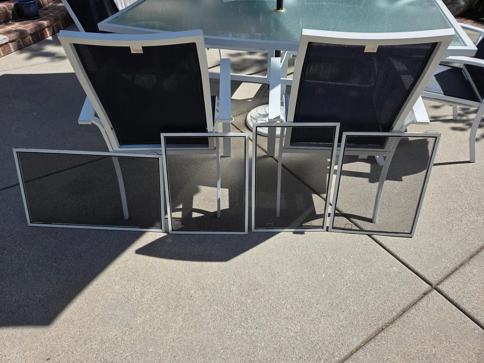 Several finished small window screens with different proportions arranged together outdoors for size comparison